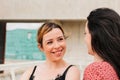 Two female friends talking and laughing outdoors. real life and friendship concept Royalty Free Stock Photo