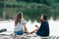 Two female friends talking at a pier relaxing on lake Royalty Free Stock Photo