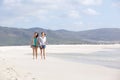 Two female friends walking on empty beach together Royalty Free Stock Photo