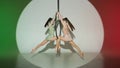 Two female gymnasts on red green studio background. Girls aerial dancers showing acrobatic element on ring with