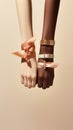 Two female hands adorned with satin ribbons and bracelets on neutral background Royalty Free Stock Photo