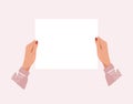 Two female hands hold a blank sheet of paper for text, a banner with copy space, a blank for an advertising message Royalty Free Stock Photo