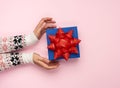 Two female hands hold a gift paper box on a pink background Royalty Free Stock Photo