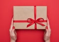 Two female hands hold a nice gift box tied with red ribbon Royalty Free Stock Photo