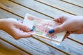 Two female hands pass the tutu of five-thousandths Russian ruble bill