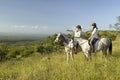 Two female horseback riders on horseback ride at sunset overlooking Lewa Wildlife Conservancy in North Kenya, Africa