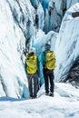 Two female ice climbers looking into a huge crevasse on a glacier in remote Alaska Royalty Free Stock Photo