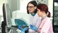 Two female lab workers operating analysing machines using computer Royalty Free Stock Photo