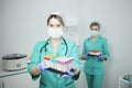 Two female nurse doctor in a medical mask hold test tubes for a blood test