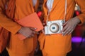 two female promoters in identical suits with a camera and a tablet