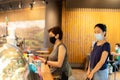 Two female in protective mask buying coffee from coffee shop.