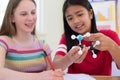Two Female Pupils Using Molecular Model Kit In Science Lesson