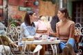 Two female students chatting while have a drink in bar`s garden. Leisure, bar, friendship, outdoor Royalty Free Stock Photo