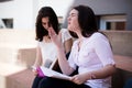 Two female students preparing for exams together outdoors on the campus Royalty Free Stock Photo