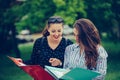 Two female students learning reading a notebook and commenting in the street Royalty Free Stock Photo