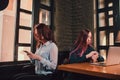 Two female students or lesbians having fun during coffee break at cafe, second half distract from work. Royalty Free Stock Photo