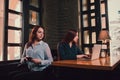 Two female students or lesbians having fun during coffee break at cafe, second half distract from work. Royalty Free Stock Photo