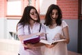 Two female students preparing for exams together outdoors on the campus Royalty Free Stock Photo