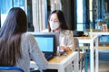 Two female students wearing face masks working on their computers in a restaurant. New normal in restaurants. Royalty Free Stock Photo