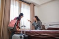 two female travelers chatting while looking at something in the window