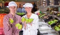 Two female warehouse workers demonstrating ripe pears