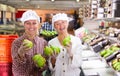 Two female warehouse workers demonstrating ripe pears