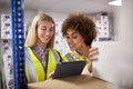 Two Female Workers In Logistics Distribution Warehouse Using Digital Tablet Royalty Free Stock Photo