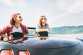 Two females friends traveling by cabriolet, have a stop brake to enjoy a mountain landsxapes