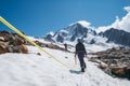 Two females Rope team members on acclimatization day dressed in mountaineering clothes walking in crampons with ice axes by snowy