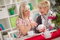 Two females talking and drinking coffee