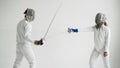 Two fencers having training attack and defence exercises in fencing on white background