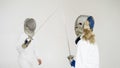 Two fencers having training attack and defence exercises in fencing on white background