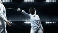 Two fencers on professional sports arena. Young athletes wearing mask and white fencing costume on duel in action. Women