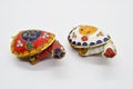 Two feng-shui colored metal turtles with detachable carapace shell for jewelry depositing on white background