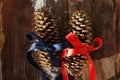 Two festive fir cones on a brown wooden background