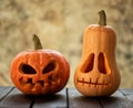 Two festive scary halloween pumpkins on a wooden table