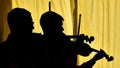 Two fiddlers silhouette and yellow background