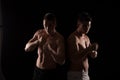 Two fighters facing each other on black background Royalty Free Stock Photo