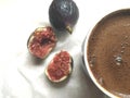 A pulp of fresh figs and mug of coffee on a white tissue