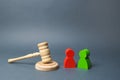 Two figures of people opponents stand near the judge`s gavel. The judicial system. Conflict resolution in court, claimant