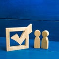 Two figures stand together next to tick in the box. The concept of elections and social technologies. Volunteers, parties Royalty Free Stock Photo