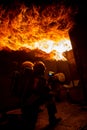 Two firefighters in a burning house full of flames while trying to put out the fire. The men wear respiratory protection equipment Royalty Free Stock Photo