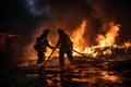 Two firefighters fighting a fire with a hose and water Royalty Free Stock Photo