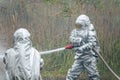 Two firefighters in protective suits works with water hose. Fighting for a fire attack Royalty Free Stock Photo