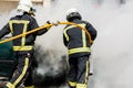 Two firefighters putting out a car fire Royalty Free Stock Photo