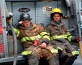 Two firefighters taking a break ifrom fire fighting at a house fire t Royalty Free Stock Photo