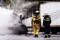 Two firemen with burning truck