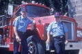 Two firemen standing in front of fire truck