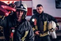 Two firemen wearing a protective uniform standing next to a fire truck. Arrival on call at night time Royalty Free Stock Photo