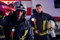 Two brave firemen wearing a protective uniform standing next to a fire truck. Arrival on call at night time Royalty Free Stock Photo